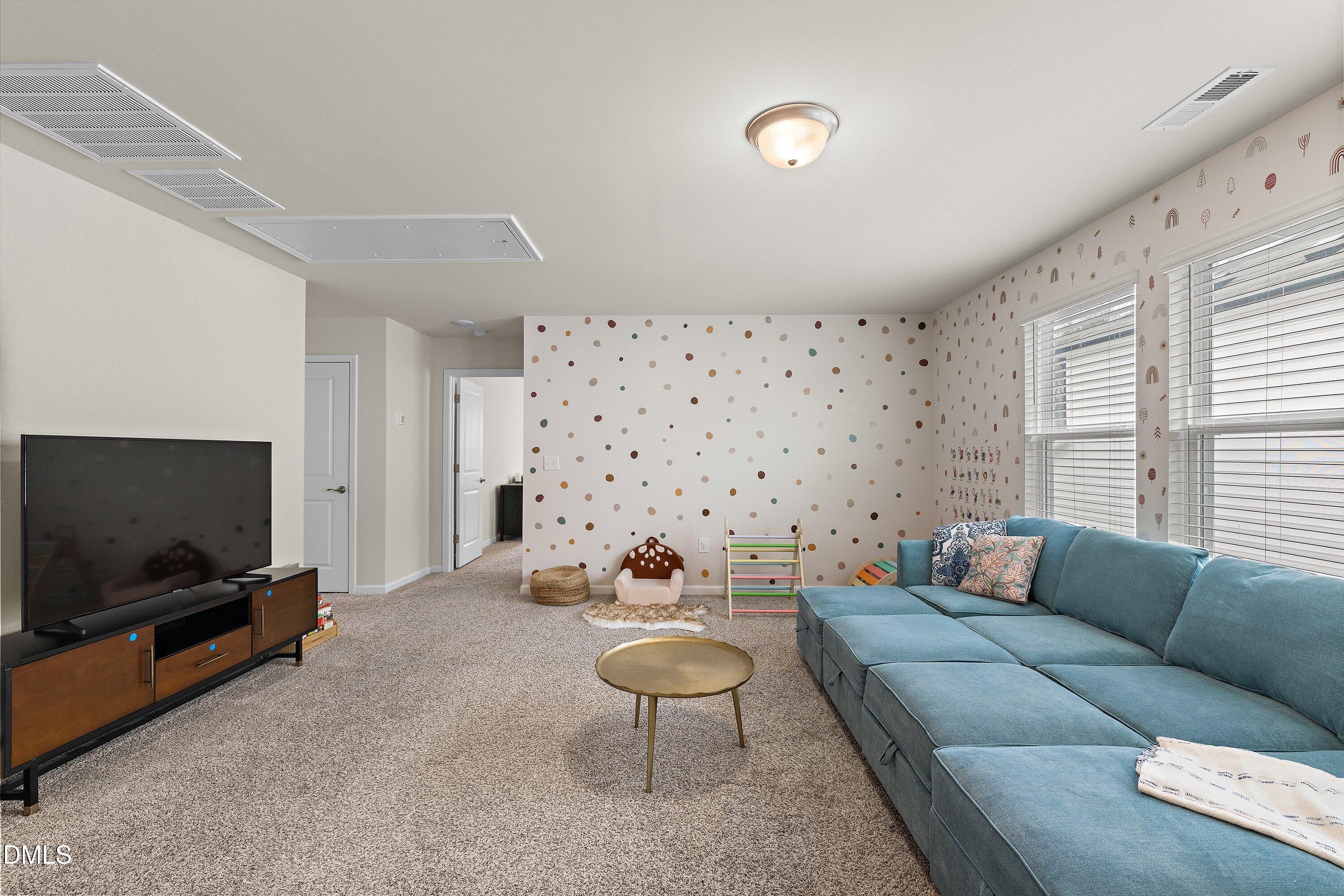 154 Anise Tree Way Clayton, NC 27527 - Photo 32 of 43 a living room with furniture and a flat screen tv