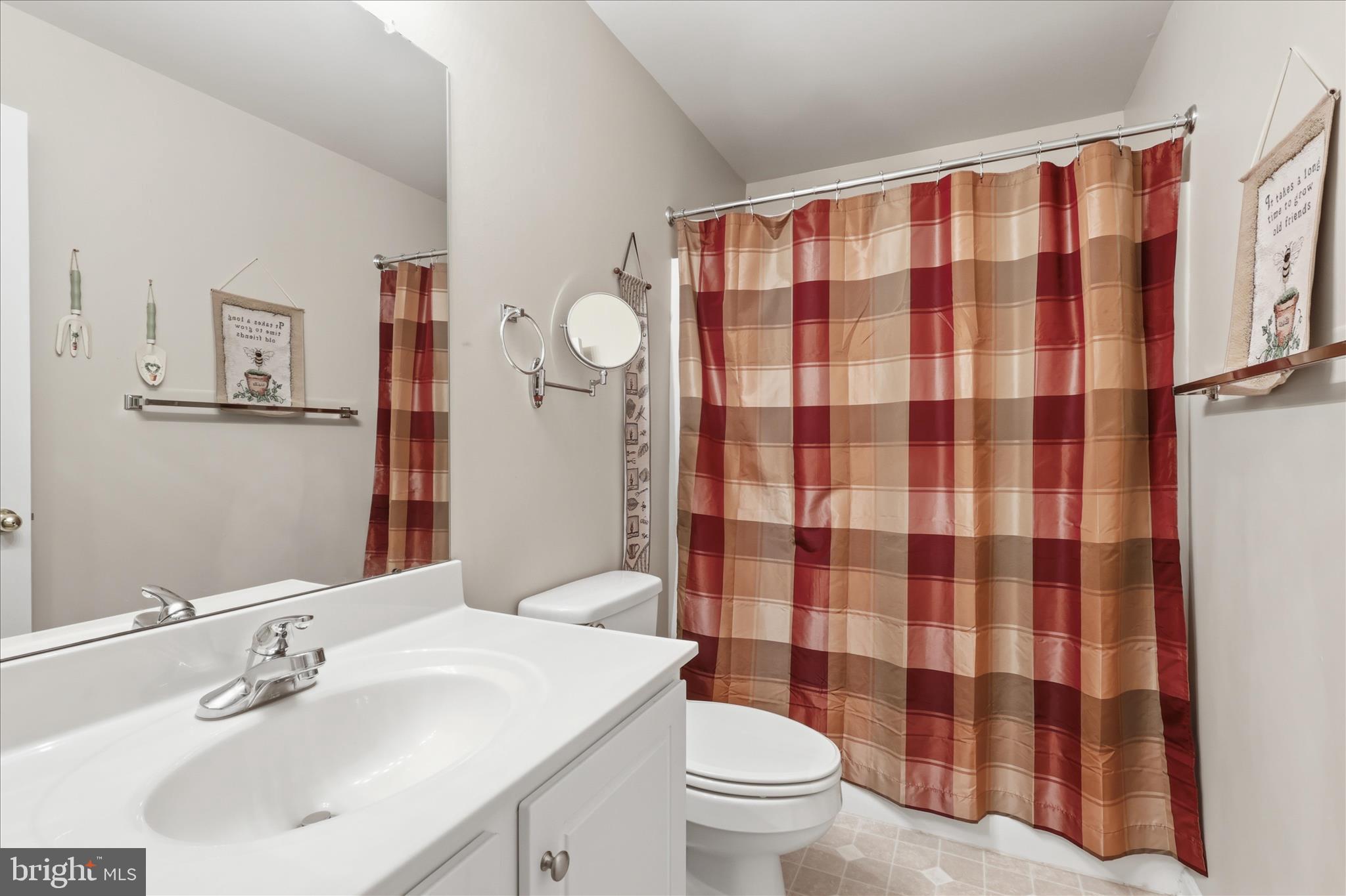 305 Tiger Way Boonsboro, MD 21713 - Photo 56 of 79 a bathroom with a sink a toilet a mirror and shower curtain