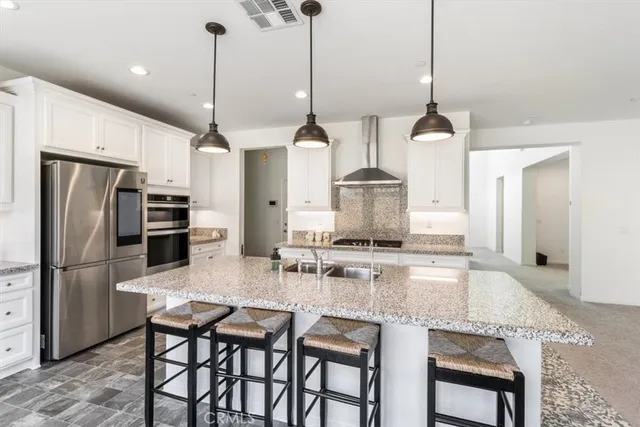 a kitchen with stainless steel appliances granite countertop a sink and a stove