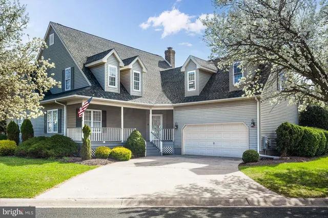 a front view of a house with a yard and trees