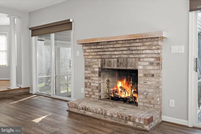 an empty room with wooden floor a fireplace and windows