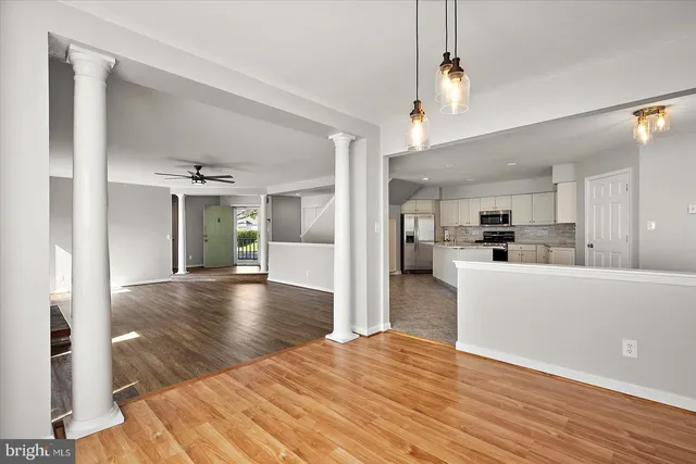 a view of a hallway with wooden floor and staircase