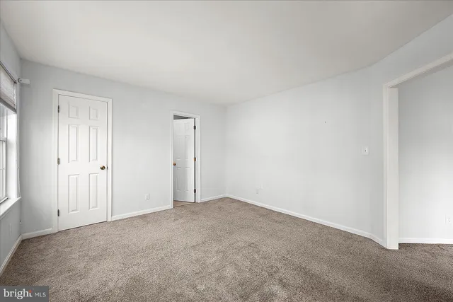 an empty room with a ceiling fan and window