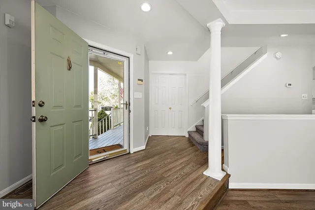 a view of an empty room with wooden floor fireplace and a window
