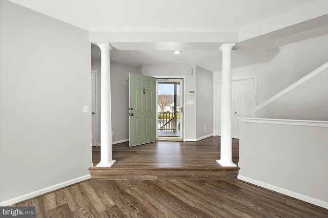 a view of a livingroom with wooden floor and a fireplace