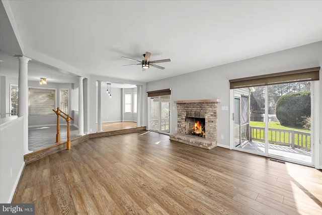 a view of empty room with wooden floor and fireplace