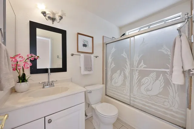 a bathroom with a sink a mirror a vanity and a shower