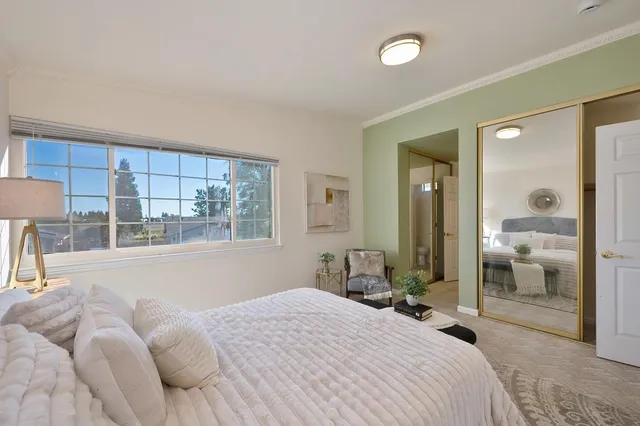 a bedroom with a bed and a large mirror