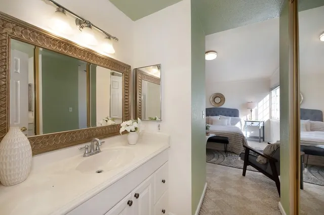 a en suite bathroom with a double vanity sink and a mirror