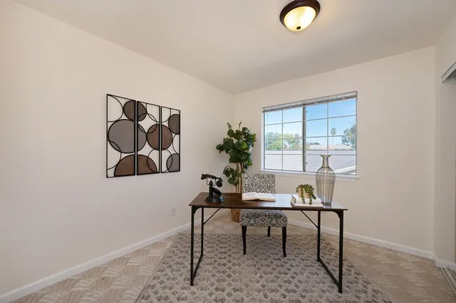 a workspace room with furniture and window