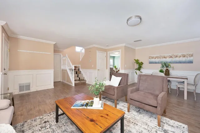a living room with furniture and wooden floor