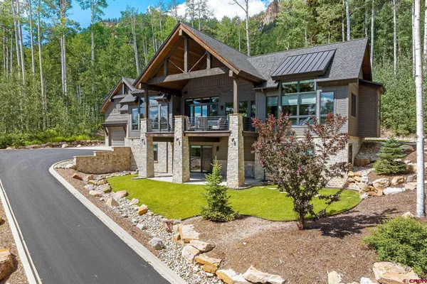 a front view of a house with a garden and trees