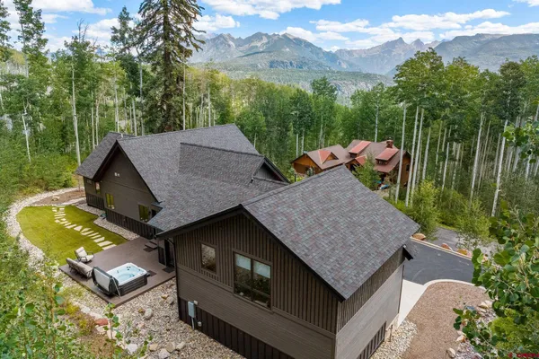aerial view of a house with balcony and trees in the background