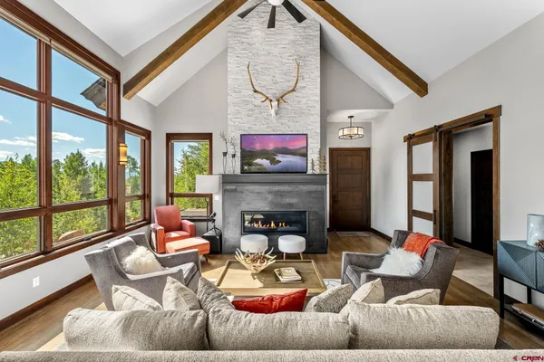 a living room with furniture a fireplace and a large window