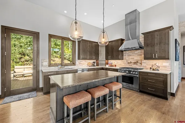 a large kitchen with granite countertop a stove a sink and a refrigerator