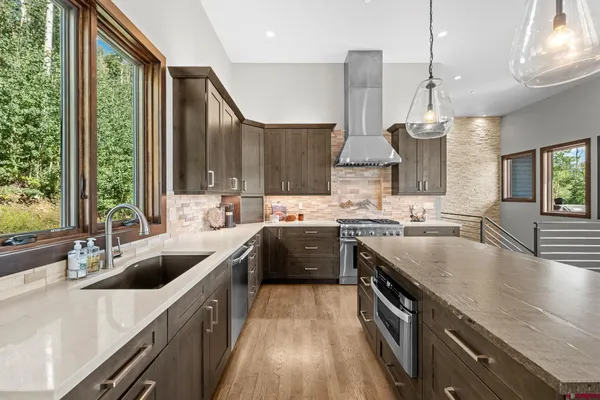 a kitchen with stainless steel appliances granite countertop a sink a stove and a refrigerator