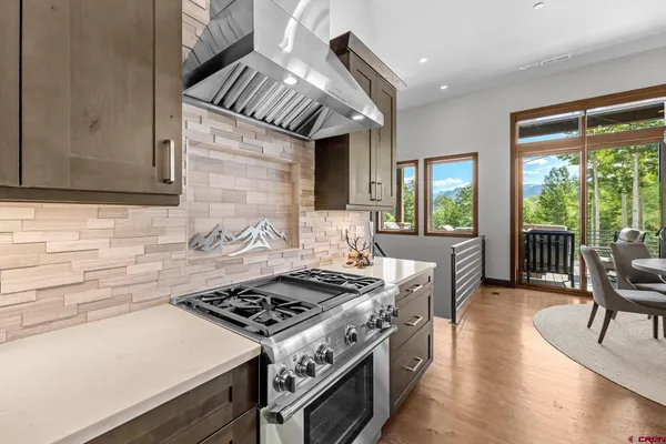 a kitchen with a stove a sink a dining table and chairs