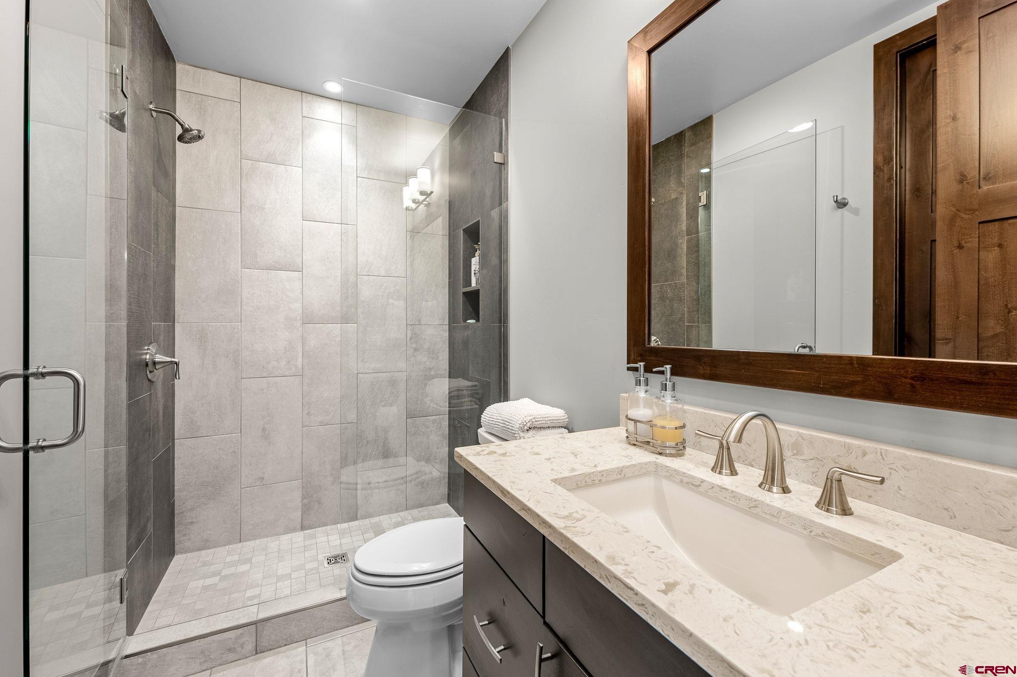 155 Long Story Road Durango, CO 81301 - Photo 43 of 45 a bathroom with a granite countertop sink toilet and shower
