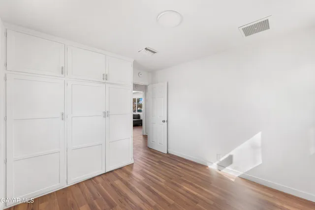 an empty room with a window and wooden floor