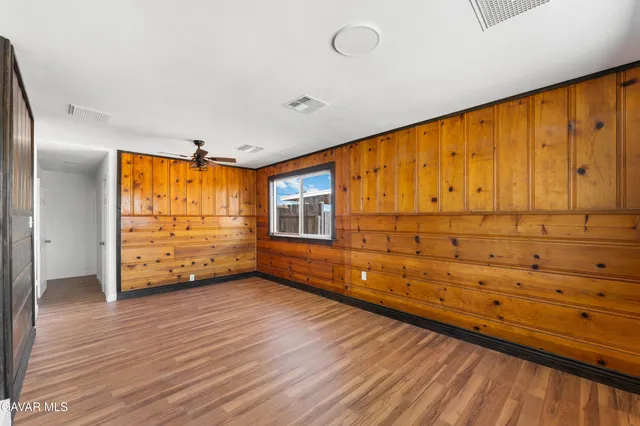 a view of a hallway with wooden floor and closet
