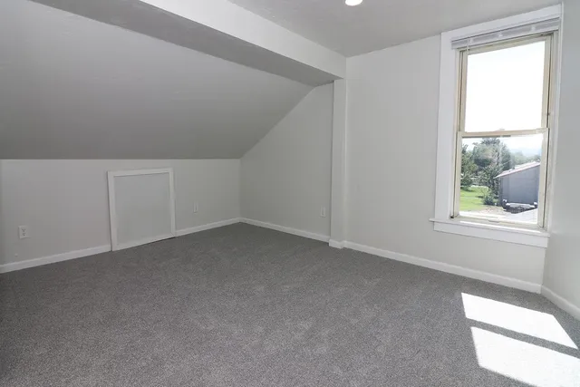 a room with stainless steel appliances furniture a rug and a window