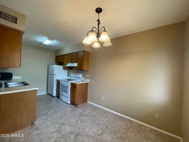 a view of a kitchen with a sink and dishwasher a stove top oven with a bookshelf
