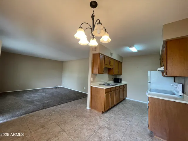 a kitchen with stainless steel appliances granite countertop a sink a stove top oven a chimney and a counter top space