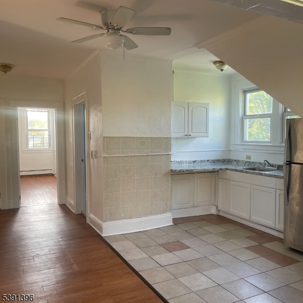 a kitchen with a sink cabinets and wooden floor