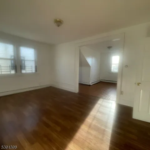 a view of a room with wooden floors and window
