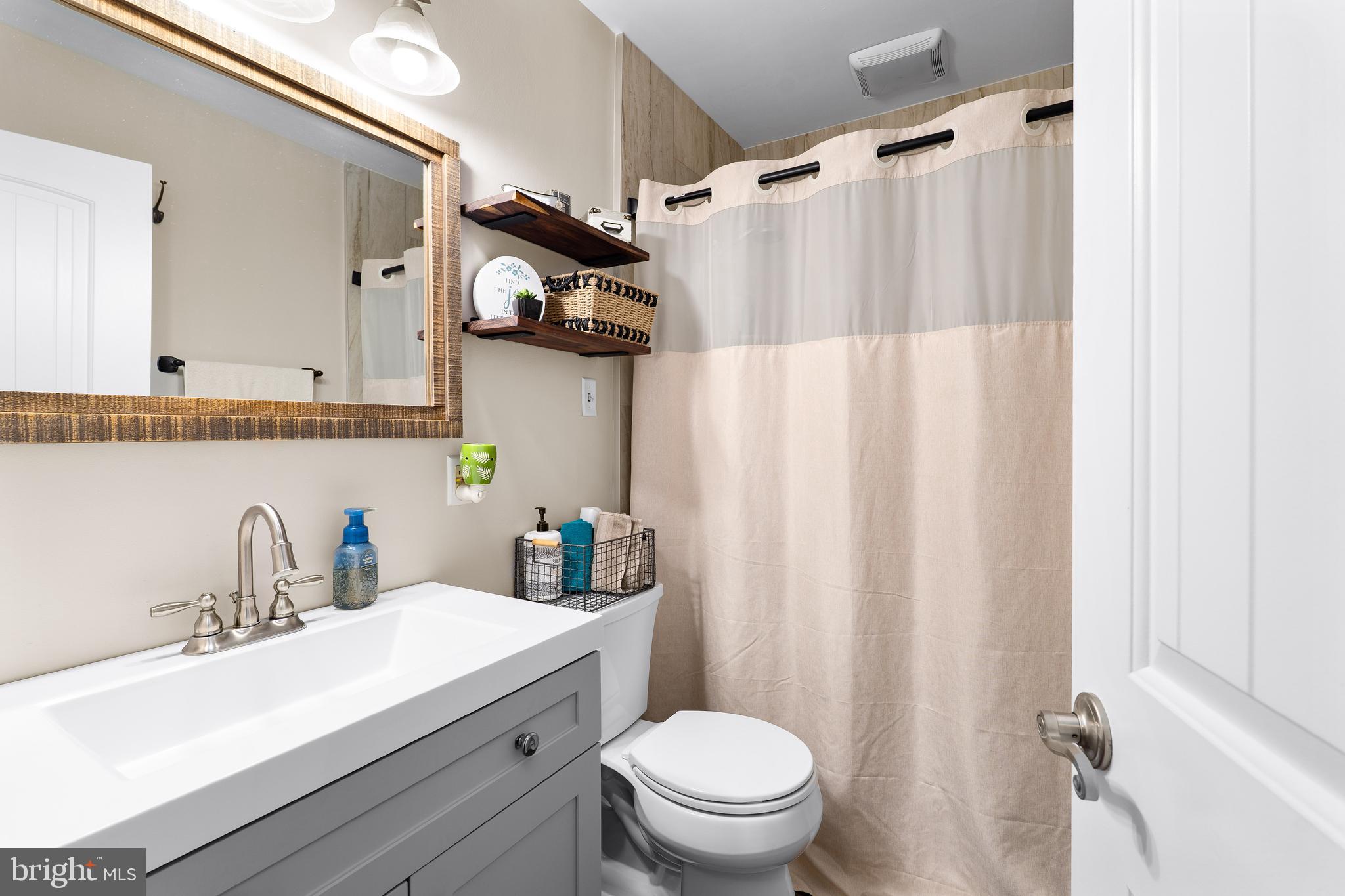 144 Bill Leight Road Conowingo, MD 21918 - Photo 13 of 28 a bathroom with a sink a toilet and shower curtain