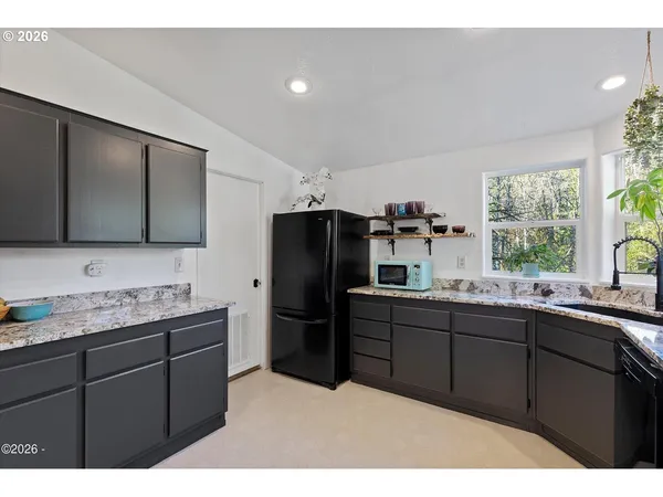 a kitchen with granite countertop a sink stainless steel appliances and cabinets