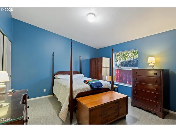 a bedroom with a bed and a dresser in it