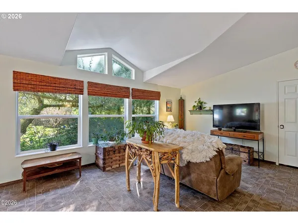 a living room with furniture a flat screen tv and a floor to ceiling window