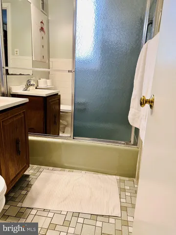 a bathroom with a bathtub sink and mirror