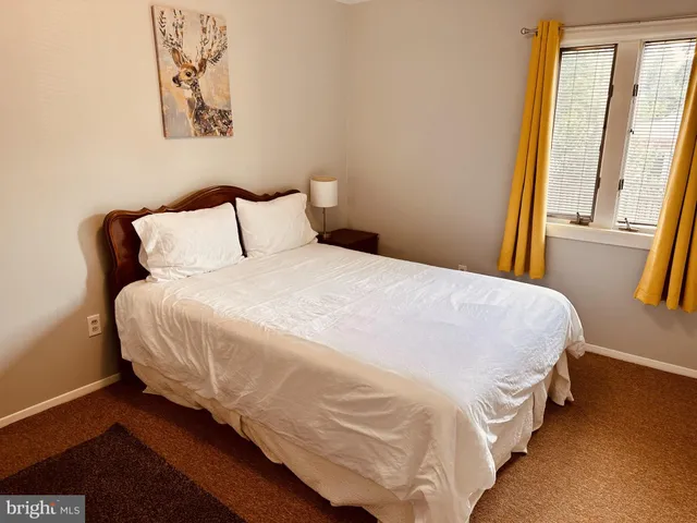 a large bed sitting in a bedroom next to a window