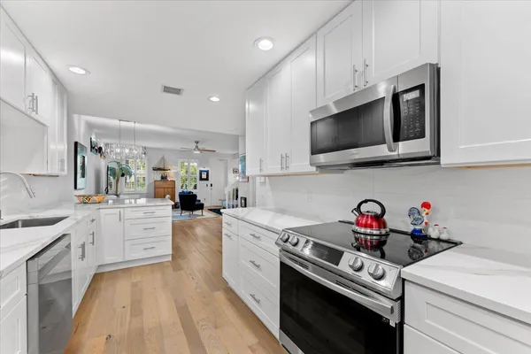 a kitchen with white cabinets stainless steel appliances and sink