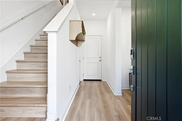 a view of a hallway with wooden floor and staircase