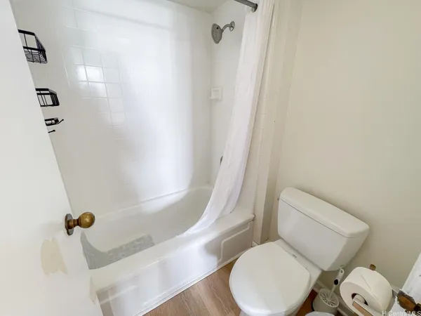 a white toilet sitting next to a bath tub