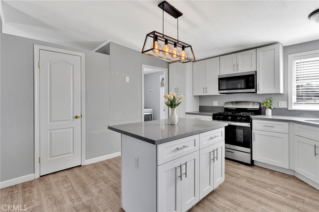 8074 Mira Mar Road Phelan, CA 92371 - Photo 11 of 49 a kitchen with stainless steel appliances granite countertop a stove a sink and a refrigerator