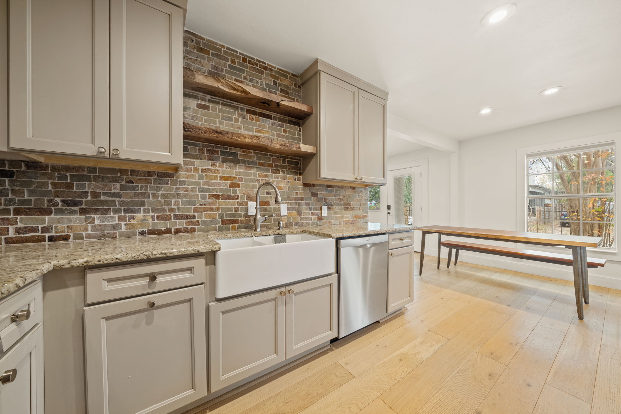 912 Mansell Avenue Austin, TX 78702 - Photo 15 of 37 Kitchen featuring open shelves, dishwasher, light stone counters, recessed lighting, and light wood-style floors