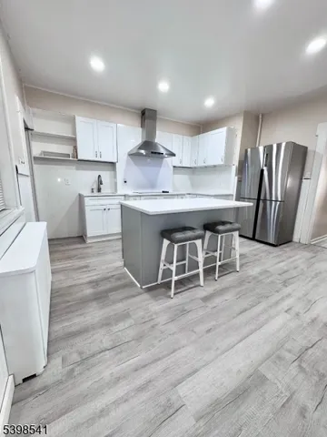 a kitchen with stainless steel appliances granite countertop a white cabinets and wooden floor
