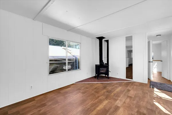 a view of a big room with wooden floor and windows