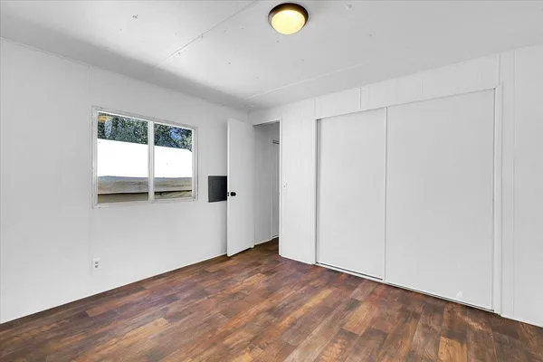 an empty room with a window and closet