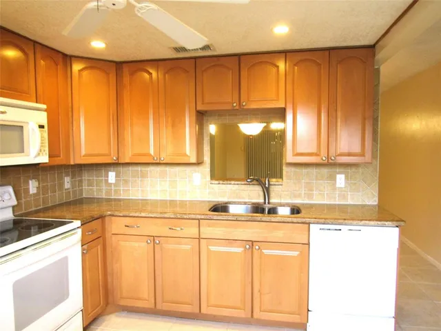 a kitchen with stainless steel appliances granite countertop a sink and dishwasher with cabinets