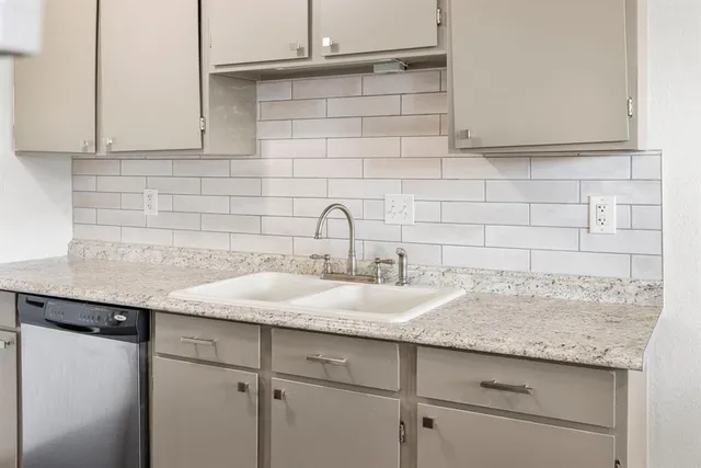 a sink with a granite countertop white sink and cabinets