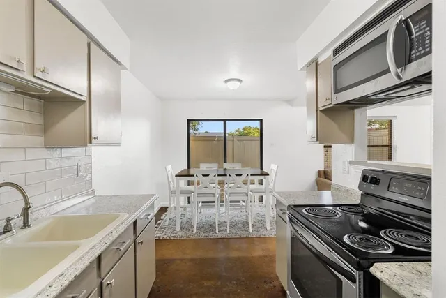 a kitchen with stainless steel appliances granite countertop a stove and a sink