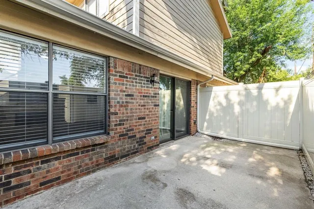 a view of backyard with window and brick wall