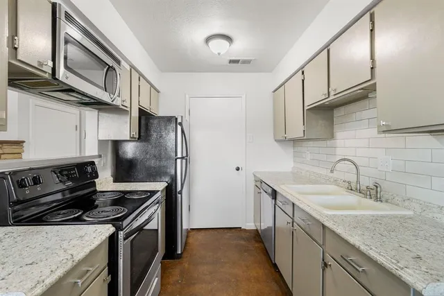 a kitchen with stainless steel appliances granite countertop a sink stove and refrigerator