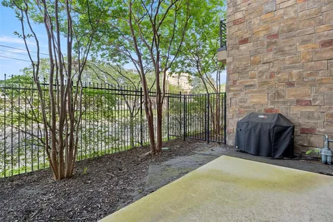 a view of a backyard with large trees and wooden fence