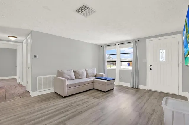 a living room with furniture and wooden floor